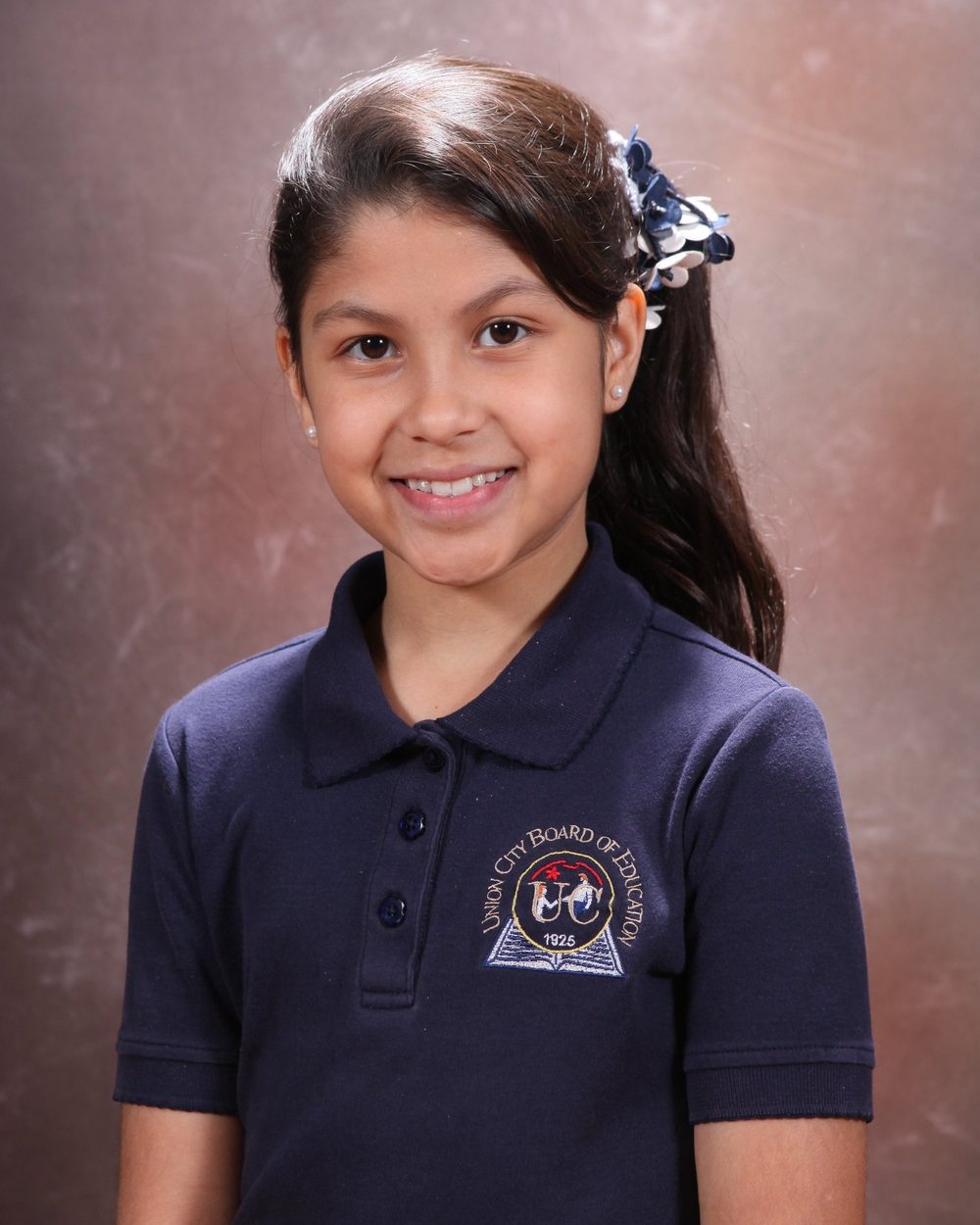 Girl in her school uniform smiling for her portrait