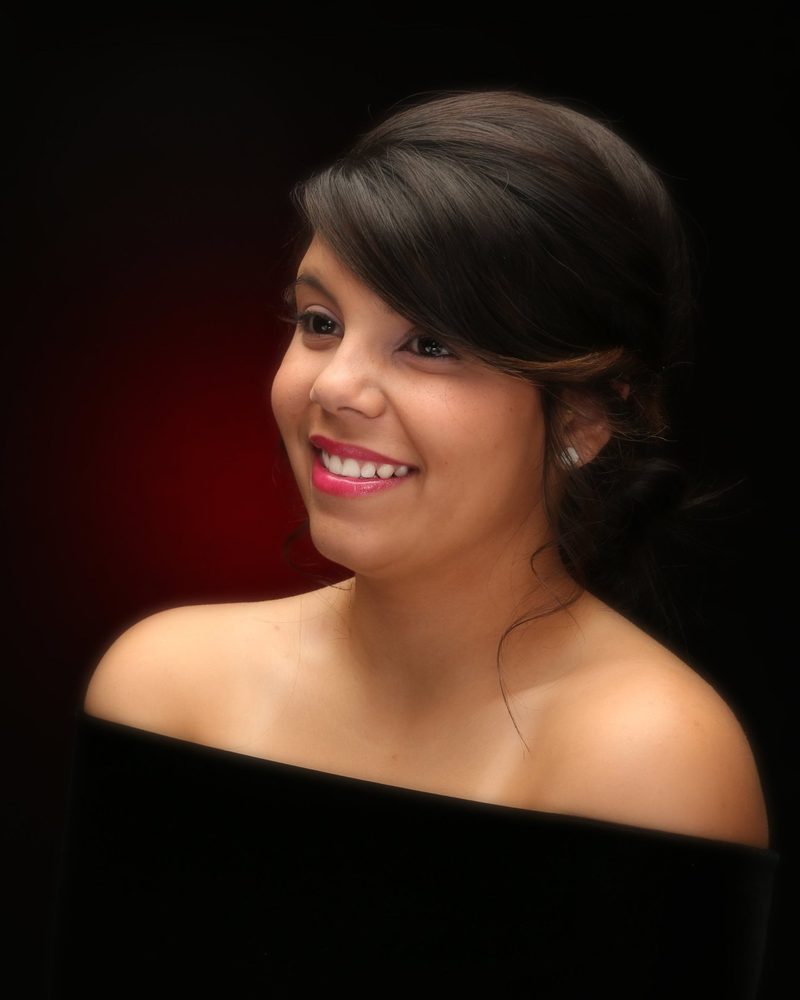 Smiling girl in a classic studio portrait on a dark red backdrop