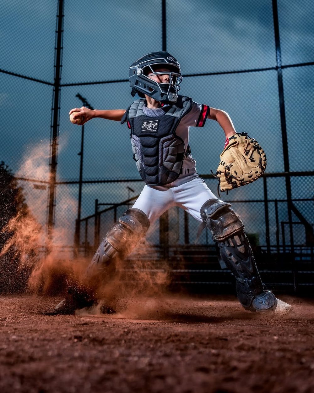 Young catcher in full gear with dramatic smoke lighting